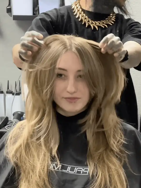 Short looping clip of C X A styling a client's long, layered blonde hair in the salon
